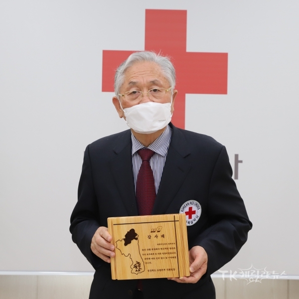 류시문 대한적십자사 경북지사 회장이 경상북도 소방본부로부터 받은 감사패를 들고 기념 촬영을 하고 있다. 사진=경북적십자사