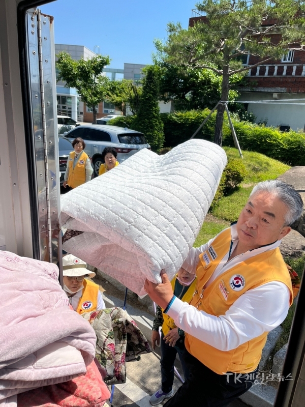 봉사원이 이동세탁차량에 세탁할 이불을 싣고 있다.사진=경북적십자사